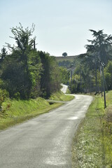 Fototapeta na wymiar Route de campagne au milieu de la végétation luxuriante vers le bourg de Champagne au Périgord Vert