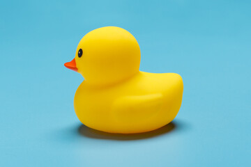 nice toy yellow duckling isolated on blue background, side view
