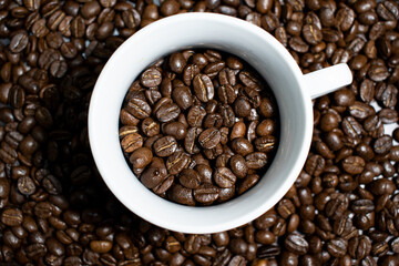 Cup of coffee full of coffee beans.