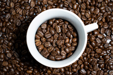 Cup of coffee full of coffee beans.