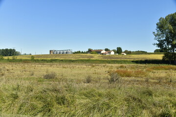 Fototapeta na wymiar Fermes et silos à grains au bout des prairies près du bourg de Champagne au Périgord Vert 