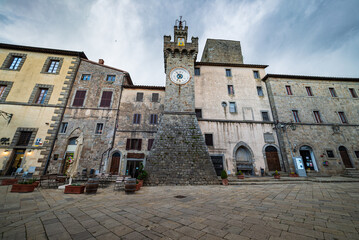 Italian medieval village details, historical stone square and ancient clock tower, old city stone buildings architecture. Santa Fiora, Tuscany, Italy.