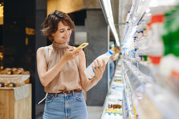 Young woman in casual clothes backpack shopping at supermaket store buy dairy produce take milk...