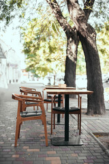 Fototapeta na wymiar Outdoor empty street restaurant with wood stile chairs. Coronavirus crisis