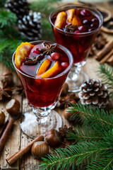 Christmas hot drink in glass and spices on wooden table