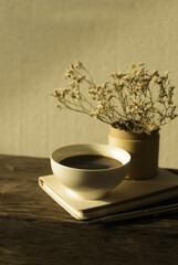 cup of coffee and a book on a wooden background