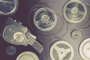 Old amateur movie camera, spools of roll film and reel of film stock