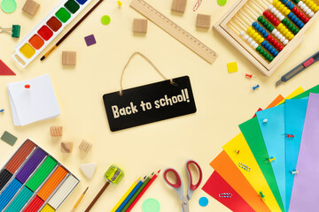 School and office supplies border on beige paper background. Multicolored pencils, paints, plasticine, abacus, pushpins and other school accessories