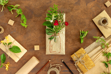 Gift wrapped in wrapping paper with bouquet of crimson roses and painted vase. Rolls of vintage...