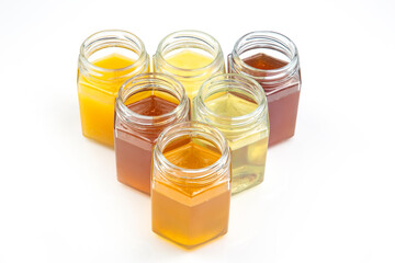 jars with different types and colors of honey on a white background. organic vitamin food