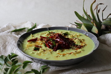 Pineapple pachadi. A yogurt based sweet and spicy curry made with pineapple, coconut, mustard seeds and curd. A side dish for Kerala meals