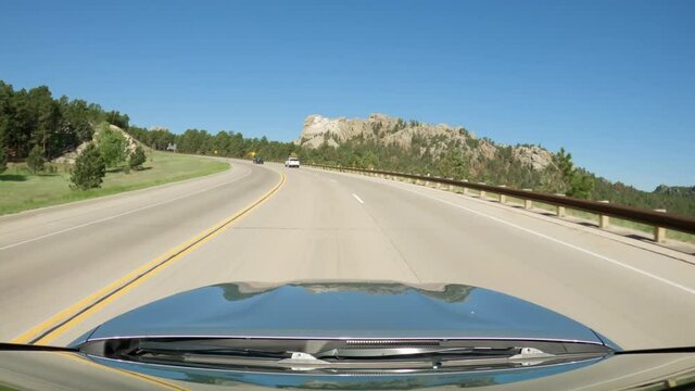 POV Driving A Car Going Up On Asphalt Road In South Dakota Near  Mount Rushmore National Memorial. Blue Sky On Sunny Day