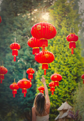 Obraz premium Young woman try to get chines lamp on a street