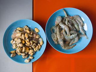 Crawfish, mussel and prawn on the blue plate and colorful table