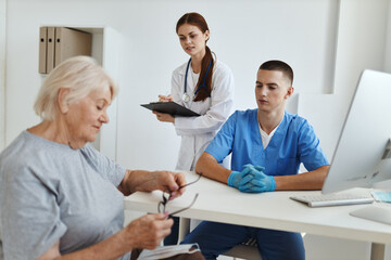 Obraz premium elderly woman patient at a reception in a medical office with a doctor nurse