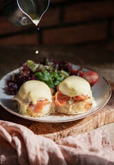 Eggs Benedict with smoked salmon, Hollandise sauce and green salad