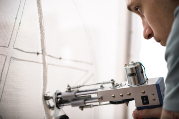 Artisan making carpet with tufting machine in workshop 