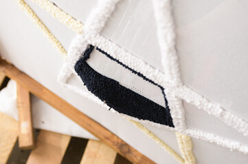 Top view of needle of rug tufting machine near canvas with pattern 