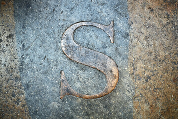 Letter S carved on the stone. Alphabet letter on granite. Stone engraving