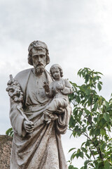 Fototapeta na wymiar The old statue of St. Joseph with Jesus in his arms at the church in Sadow near Lubliniec in Silesia