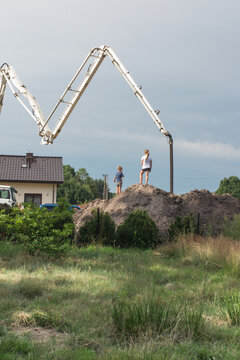 children watch concrete pouring from a truck concrete mixer to the foundation of a new house