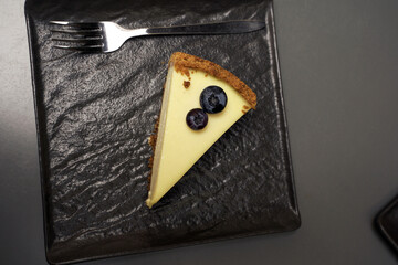 cheesecake with blueberries on a gray plate