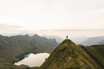 eine person auf der spitze eines berges mit wundervoller aussicht auf einen bergsee in deutschland