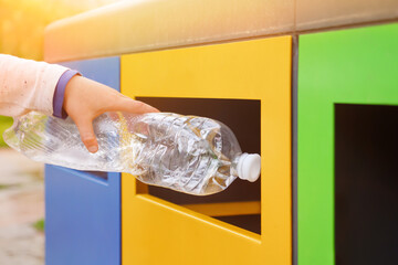 Garbage recycling plastic trash bins. Close up hand throwing plastic bottle recycling container...