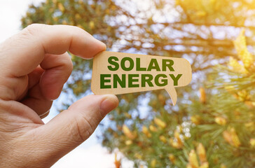 A man holds a sign inside which the inscription - Solar Energy