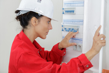 female electrician working on circuit breaker cabinet