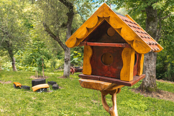 Brown, handmade wooden bird house in the backyard in countryside