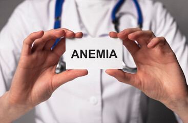 Anemia word on paper in doctor hands close up.