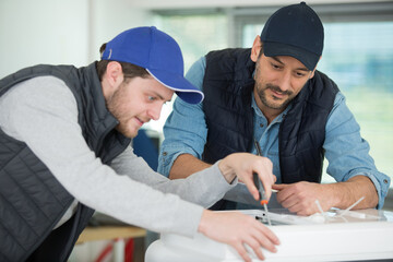 ac apprentices and teacher repairing air conditioning compressor