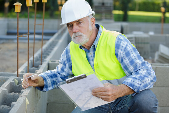 senior man checking cement blocks