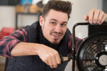 happy technician fixing a fan