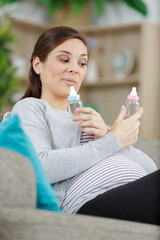 pregnant woman holding baby bottle
