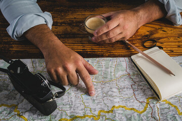 Detail of a man hand pointing out a destination on a map