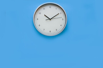 Wall clock on Blue wall. Copy Space concept