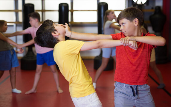 Two boys in sparring practice self defense technique in the gym