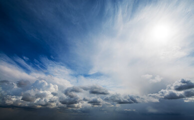 Picturesque aerial view of changing weather from clear blue sky with bright sunshine and just a few white clouds to dark stormy thunderclouds completely covering the sky.