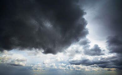 Obraz premium Picturesque aerial view of changing weather from clear blue sky with bright sunshine and just a few white clouds to dark stormy thunderclouds completely covering the sky.