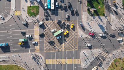 Beautiful view from above to a busy crossroad in a big city. Camera moving upwards showing cars and...