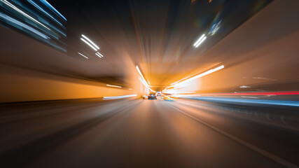 Amazing night rush drive in a big city. Speedy car driving the highway with a lot of lights and traffic, overtaking other vehicles and passing by skyscrapers along the road. © railwayfx