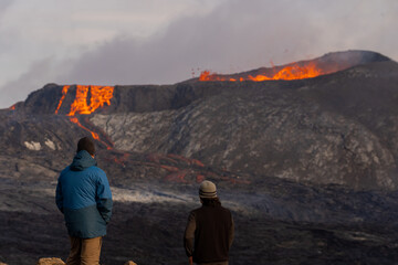 Beautiful view of the Active Grindavik Volcano with red Lava and tourists contemplating ir in Iceland