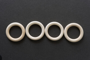 four wooden rings on dark gray paper