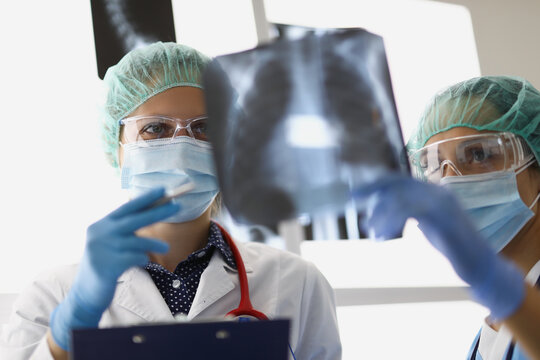 Doctors stand in the office and look at x-rays
