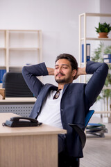 Fototapeta premium Young handsome employee working in the office