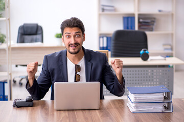 Young handsome employee working in the office
