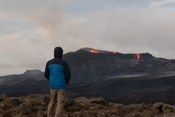 Beautiful view of the Active Grindavik Volcano with red Lava and tourists contemplating ir in Iceland