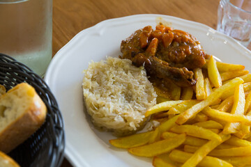 Fried potatoes, sauerkraut and chicken stewed with carrot - french peasant food